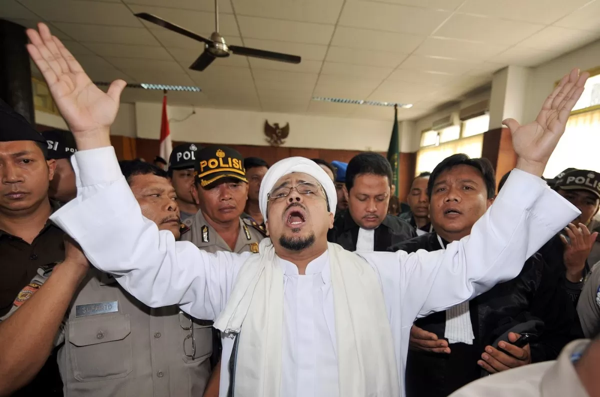 Imam Besar Front Pembela Islam (FPI) Rizieq Shihab memberikan gestur di dalam ruang sidang pada November 2018.